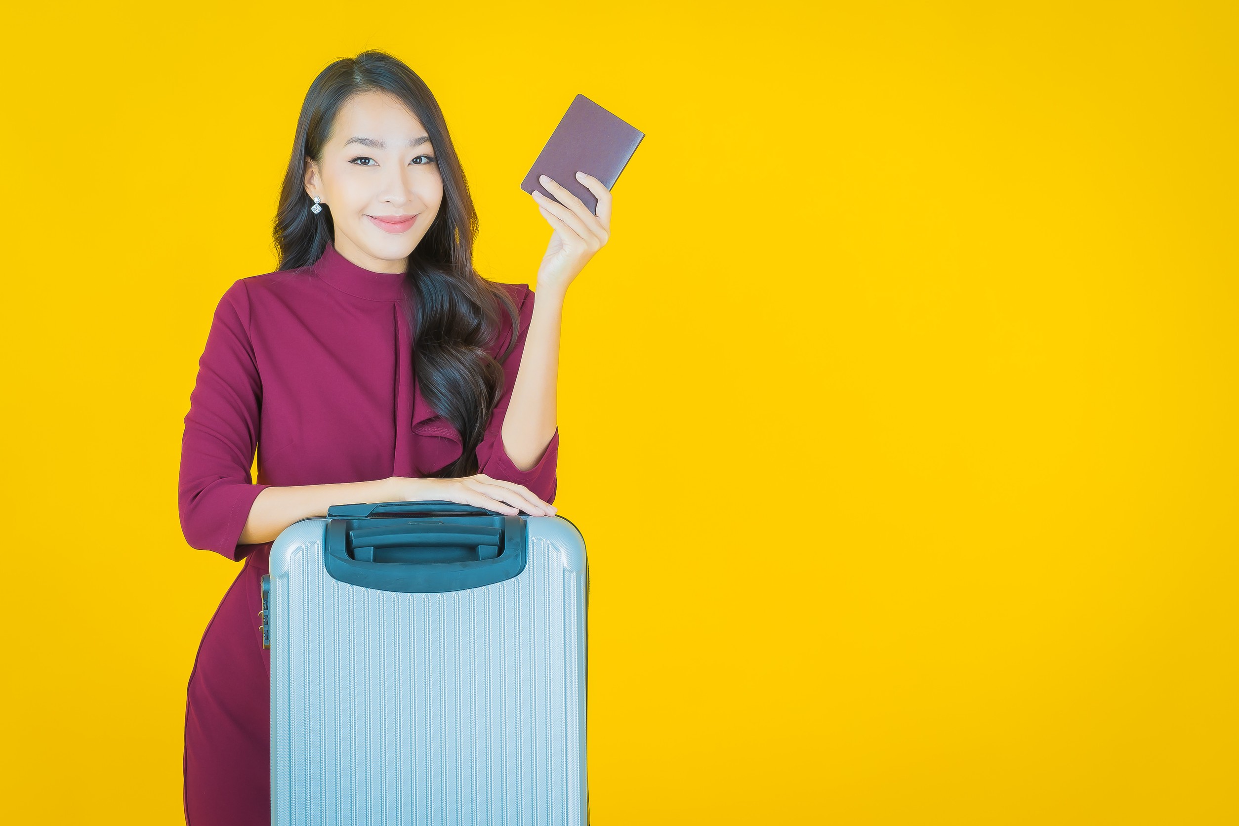 portrait of beautiful young Asian woman with luggage bag and passport