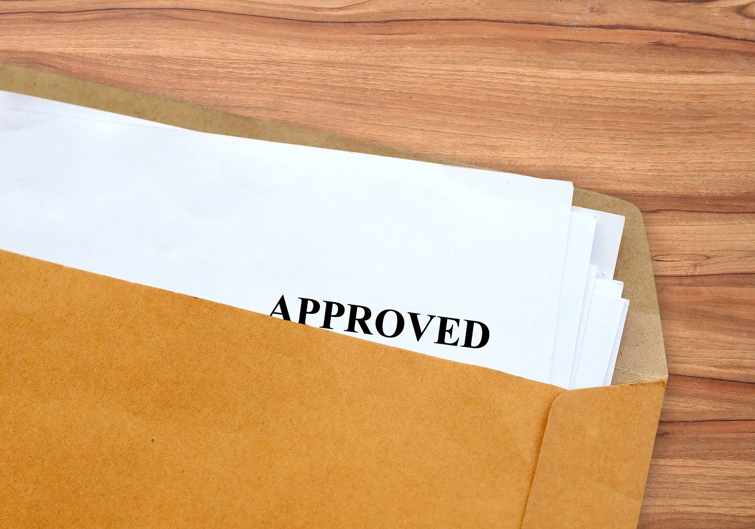 white paper in brown envelope on wooden table