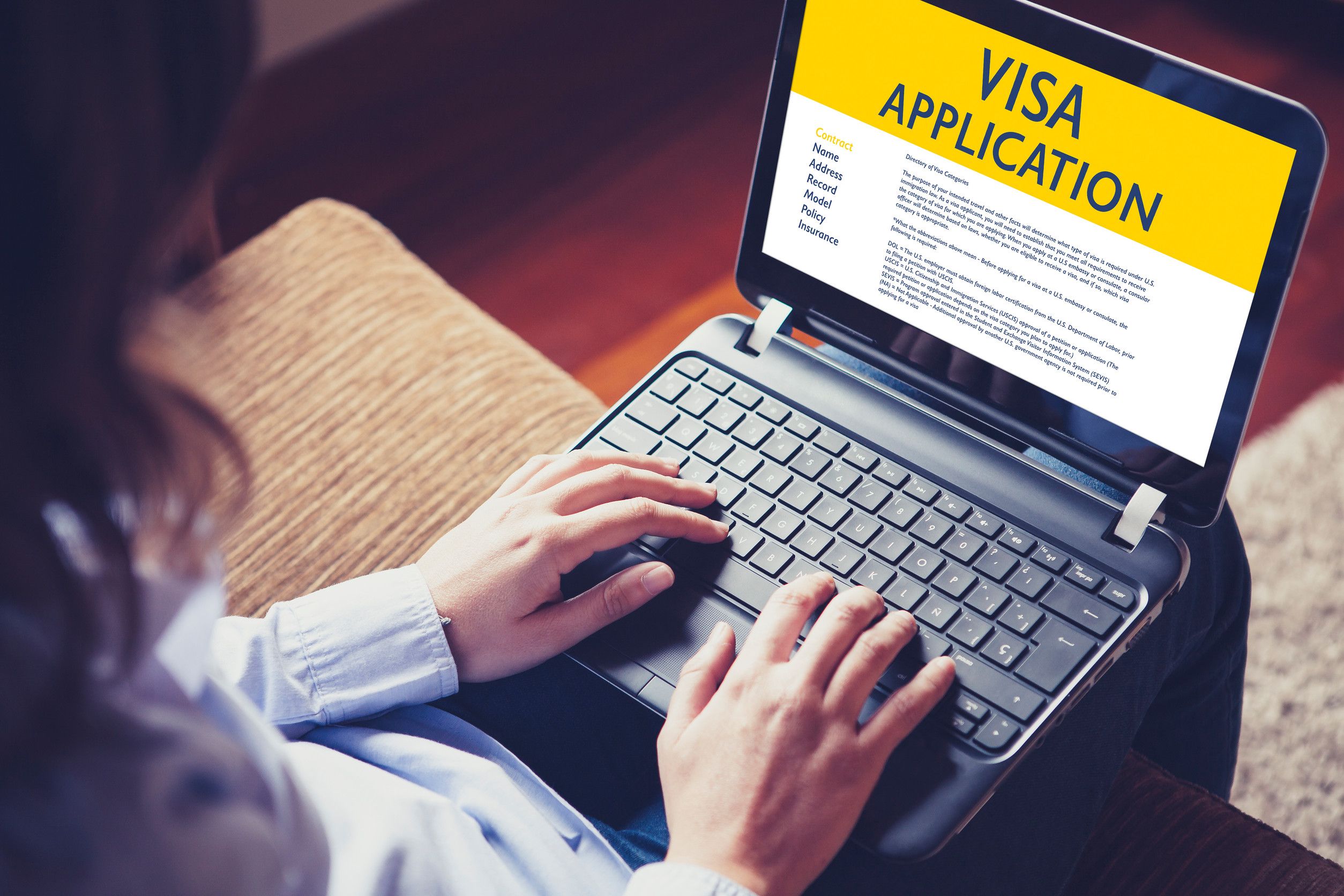 woman doing electronic immigration application in a laptop